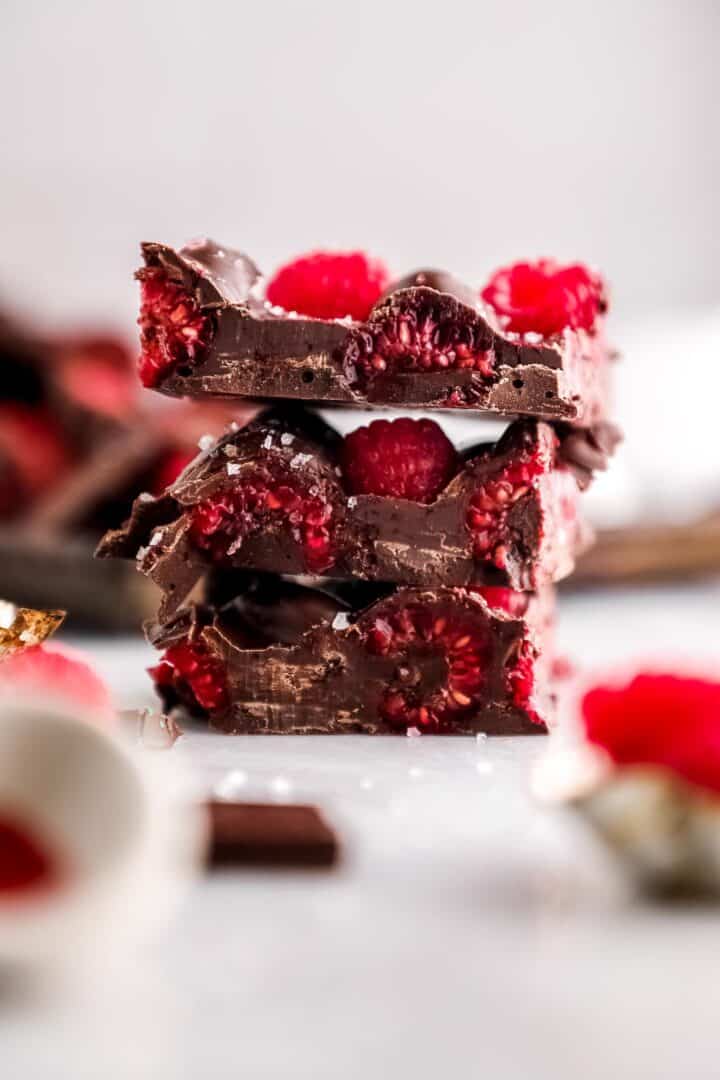 A-piece-of-raspberry-chocolate-bark,-with-pink-and-brown-swirls-and-bits-of-freeze-dried-raspberries-scattered-throughout