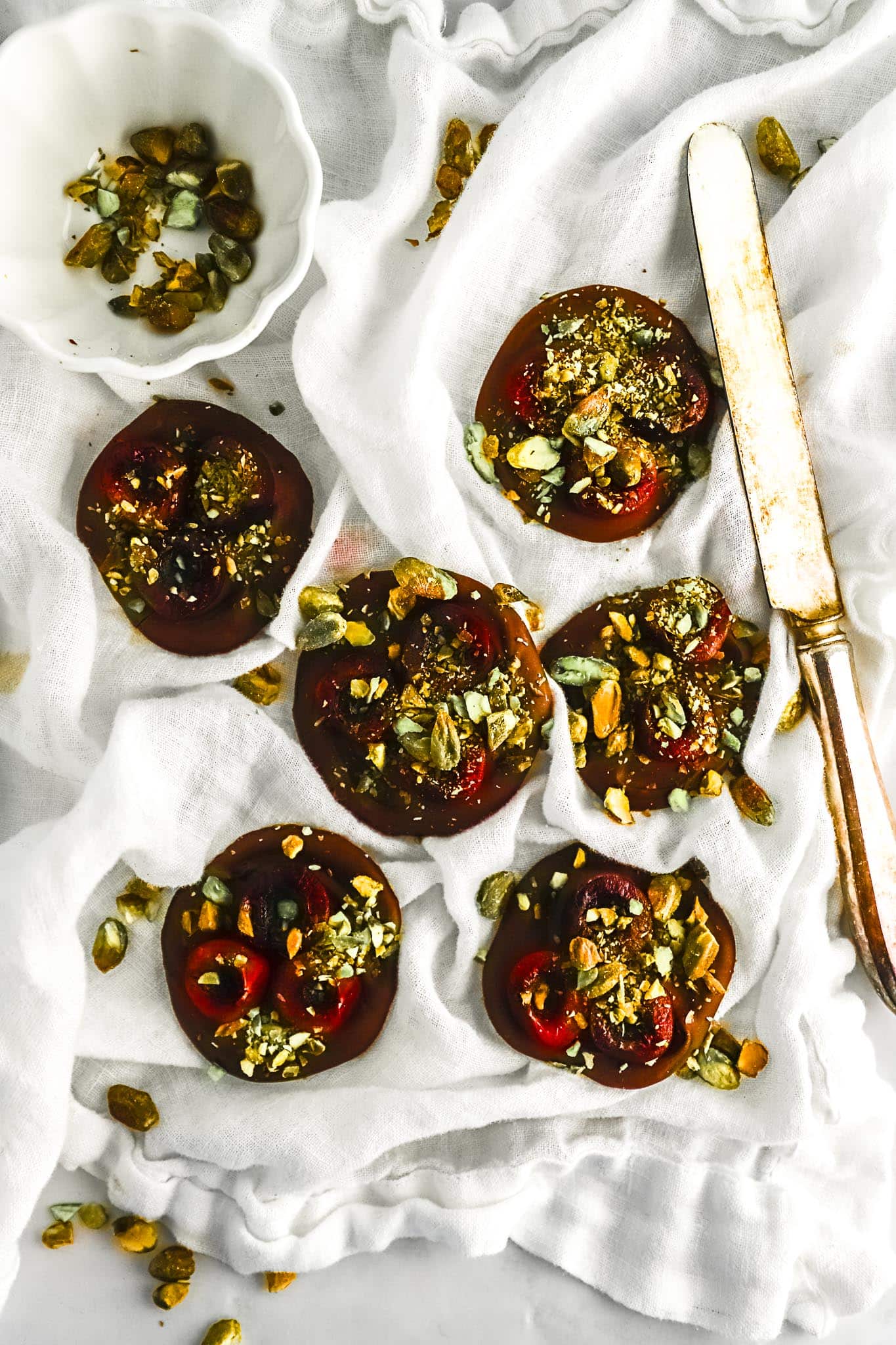 overhead-view-cherry-pistachio-chocolate-bites-with-scattered-pistachios