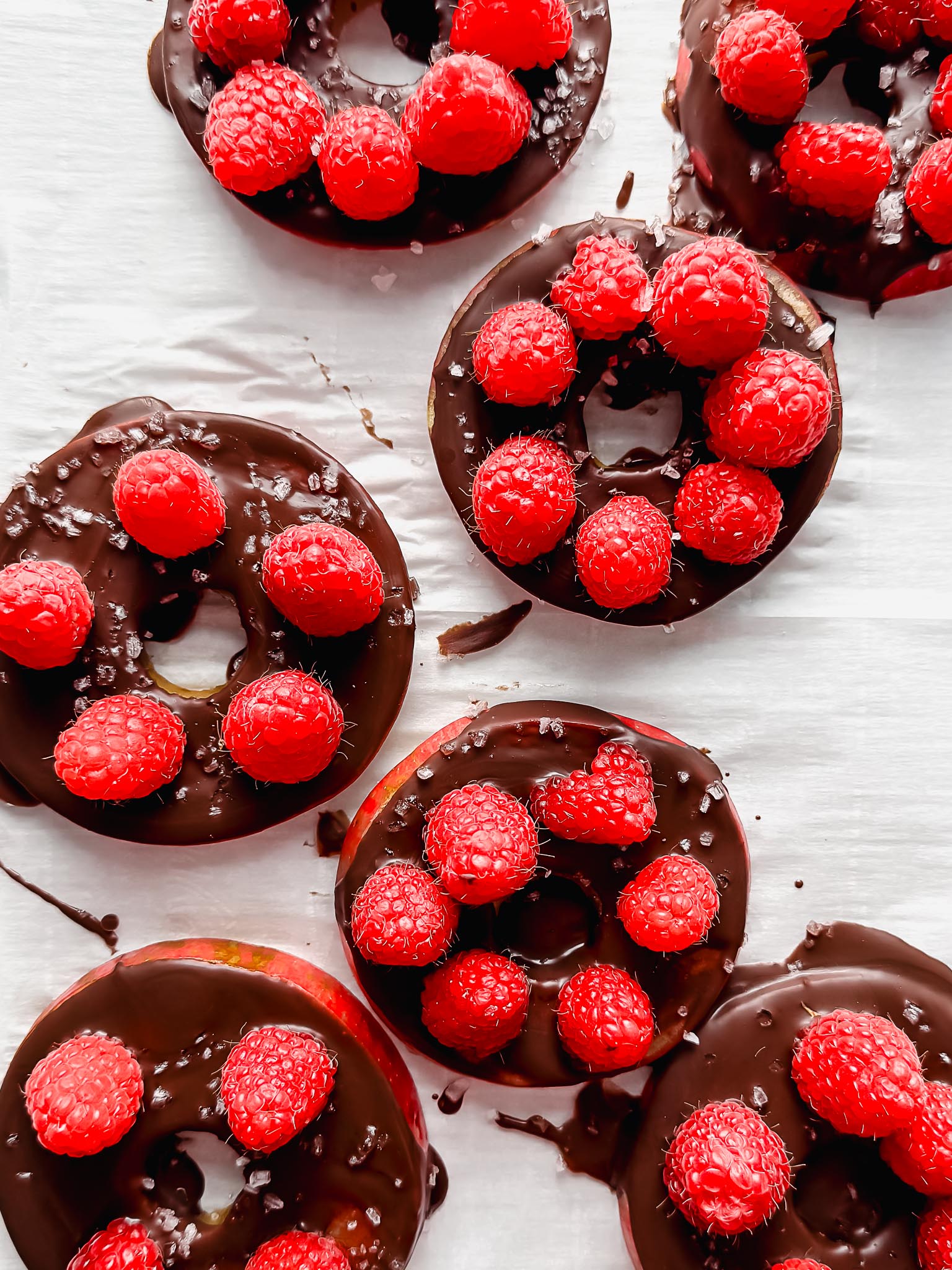 chocolate-apple-rings-with-berries-and-salt-on-parchment
