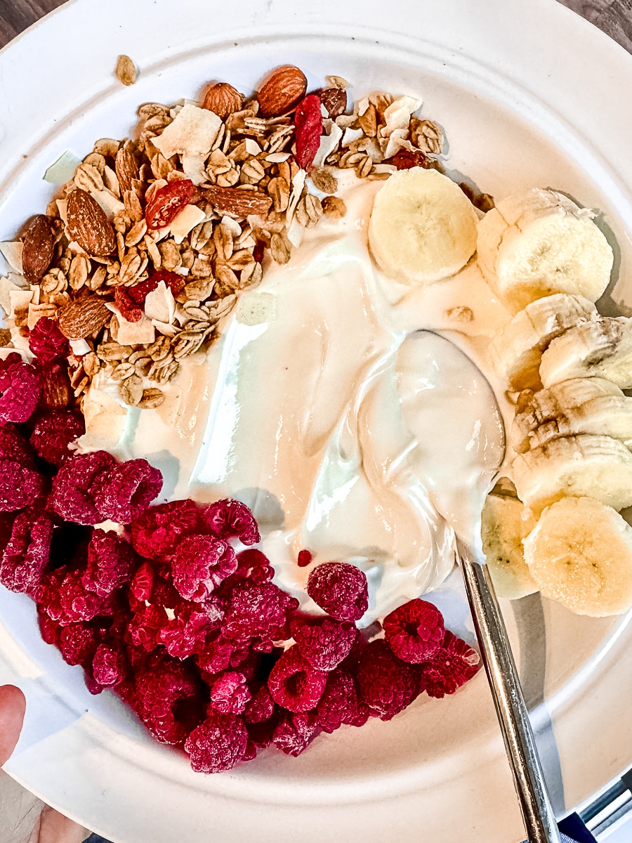 greek-yogurt-bowl-with-frozen-raspberries-banana-granola